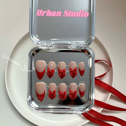 Ruby Kiss medium almond red French tip press-on nails with 3D bows