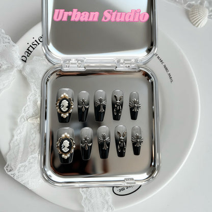 Gothic Bow Charm press-on nails in coffin shape, medium length